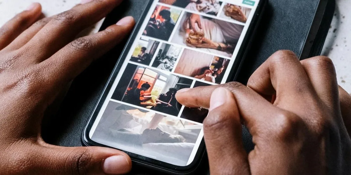 User selecting a photo to post on Instagram on their smartphone. We only see their hands and the device up close.