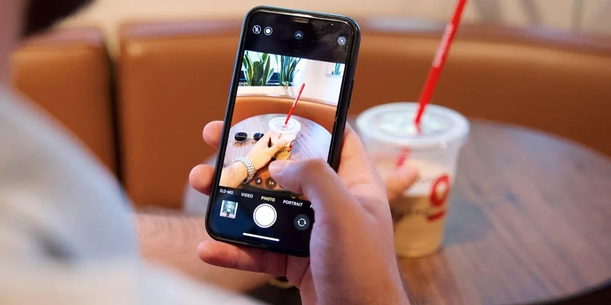 Man taking a picture of his drink with his Instagram camera.