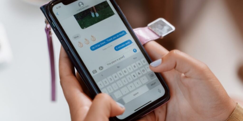 Uma mulher segurando o celular enquanto digita uma mensagem no direct. Vemos apenas suas mãos, com unhas bem feitas. O que é direct no Instagram?