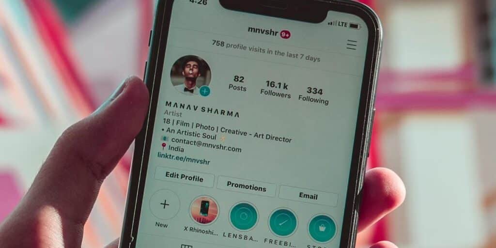 Detalhe mostrando celular nas mãos de uma pessoa, com tela ligada em um perfil não bloqueado na rede social. Como desbloquear uma pessoa no Instagram.