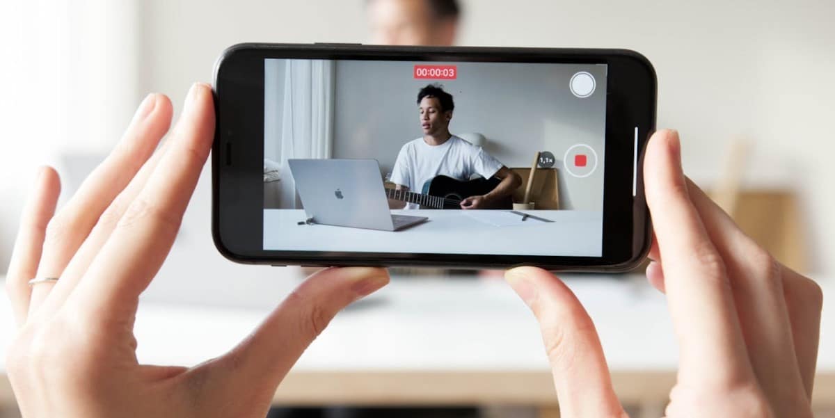 Detalhe mostrando alguém segurando um celular na horizontal enquanto grava um vídeo. Como crescer no Instagram.
