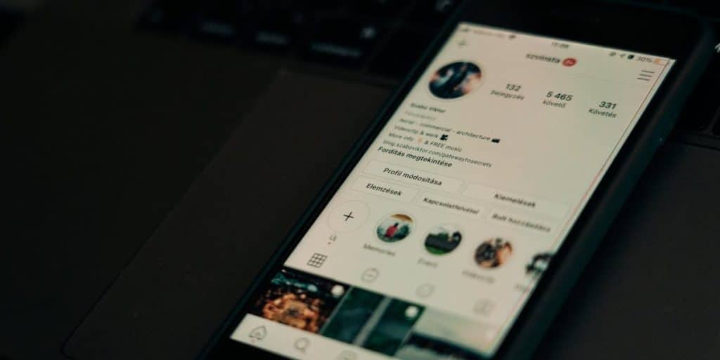 Celular sobre mesa preta ligado em perfil do Instagram real