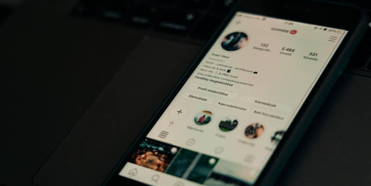 Celular sobre mesa preta ligado em perfil do Instagram real